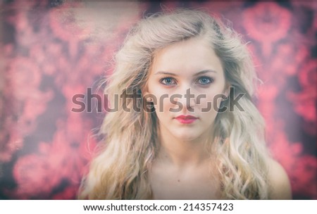 Beautiful woman with blonde curly hair against red and black damask background.