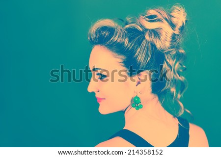Colorized profile of a beautiful smiling woman against teal background.