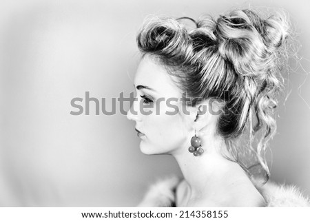 Profile of a beautiful woman wearing a mink fur against a gray background in black and white.