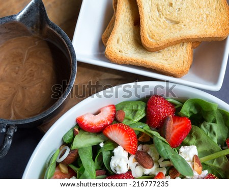 Spinach salad with strawberries, scallions, coconut toasted almonds and goat cheese, vinaigrette dressing and toast.