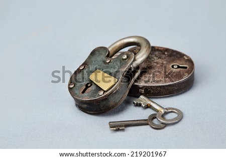 Ancient hand tooled locks and keys against grey background.