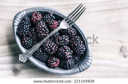 Blackberries in a pewter dish with an antique silver dessert fork.