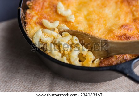 Southern style macaroni and cheese being served from a cast iron Dutch oven.