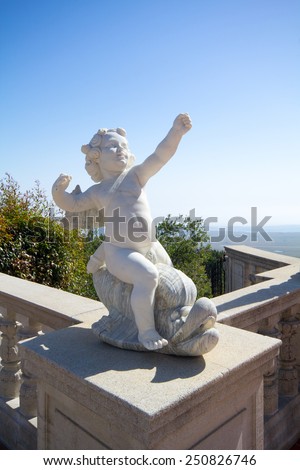 SAN SIMEON, CA, USA - April 15, 2015: Small statue of Cupid on the patio of Casa Del Mar overlooking the Pacific Ocean. Casa Del Mar is one of three guest mansions on Hearst Castle property.