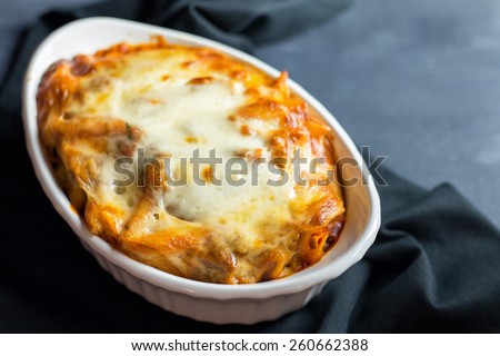 Close up of a single serving casserole dish filled with freshly baked ziti.