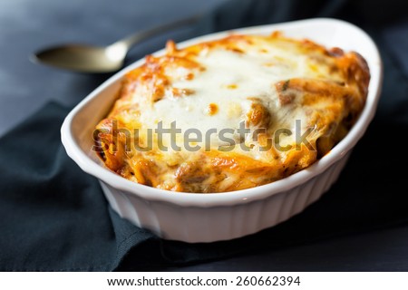 Close up of a single serving casserole dish filled with freshly baked ziti.