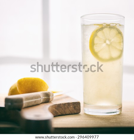 Fresh lemonade near a sunny window.  Vintage filter with film grain.