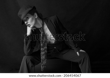 Androgynous woman wearing man\'s suit and tie with trilby hat
