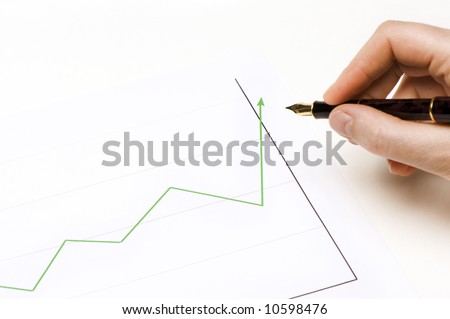 graphics showing a green line going up. Someone's hand is holding a pen and is following the lign.