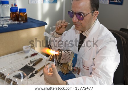Brussels,Belgium, LABORAMA fair - march 13: People watch as a man shapes glass with a glass torch.  The Fair is an annual event, intended for people in the chemical industry.