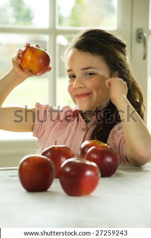 brown haired child presenting an apple. Healthy lifestyle image.