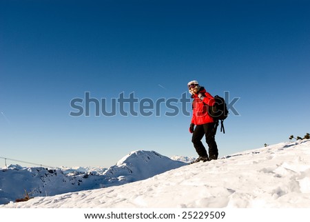 woman hiker with tourist bag on the top of a mount on winter alpine resort austria
