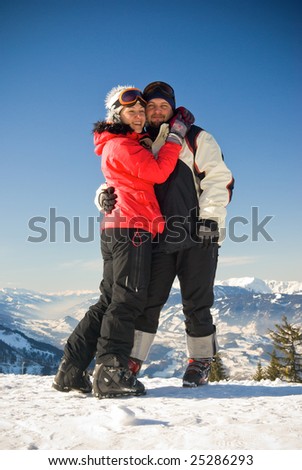 happy man and woman stay on the mount at winter alpine resort in austria