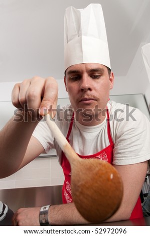 Young man with chef\'s hat stirring food