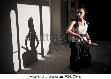 Beautiful woman unsheating sword with shadow showing her figure