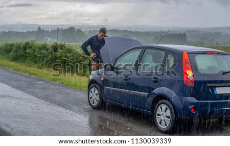 Car trouble in the rain. Broken car.