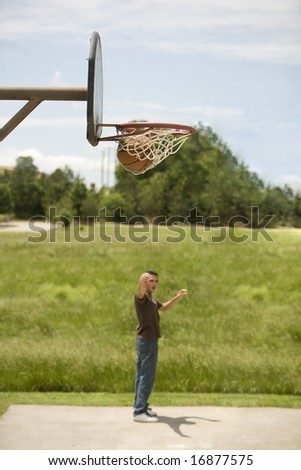 Young man making a three point shot.