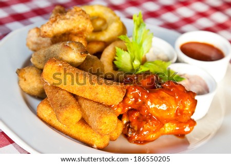 Deep-fried squid rings, mozzarella cheese sticks and chicken wings