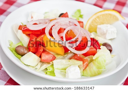 Greek salad with iceberg salad, cucumbers, tomatoes, feta cheese, olives and pepper