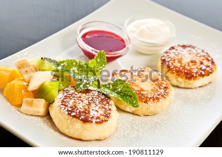 Cottage cheese pancakes with fruits, jam and sour cream