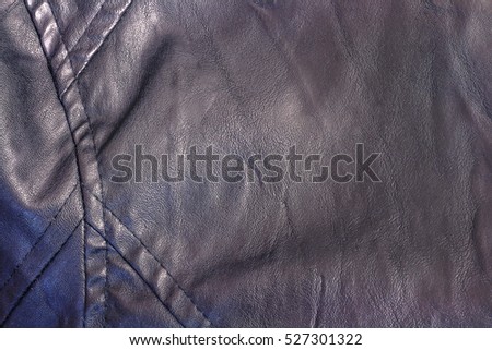 The texture of black synthetic leather ladies jacket with a seam