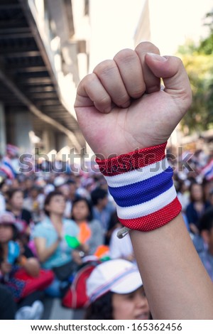 BANGKOK, THAILAND:1 DECEMBER: Unidentified arm with Thai national flag wristband puts his fist up to support anti-government protest on December 1, 2013 in front of Royal Thai Police Headquarters.