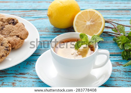 lemon tea mint fresh drink raisin cookies summer refreshment still life blue background wood teak