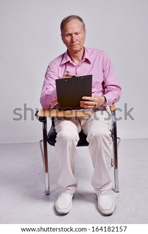 Sitting and writing Businessman on grey background