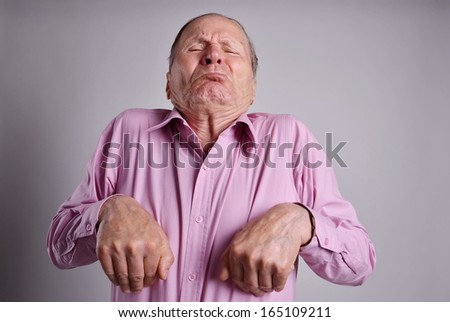 Funny Senior man with hands near chest on grey background