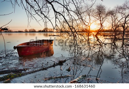 Wooden boat on a flooded river. Early spring landscape.
