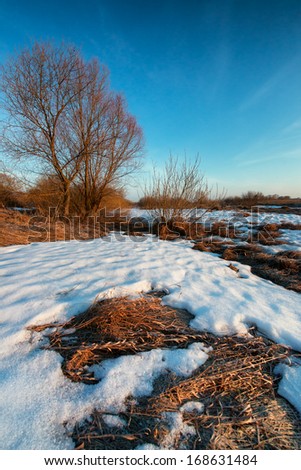 Early spring landscape. Sunrise on a flooded river with thawed ice.