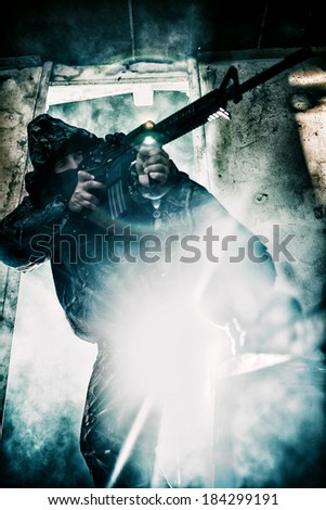 Soldier with rifle against strong light aiming ready to shoot