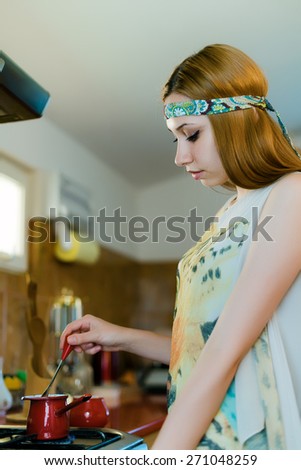 Profile of cute girl preparing the morning coffee on the stove