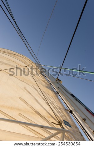 Mast, rope and sails of a yacht against an azure sky