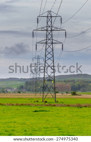 A row of electricity pylons stretches into the distance towards the South Downs