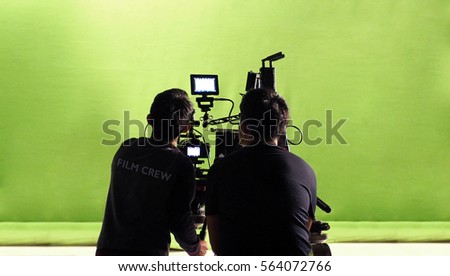 Photographer team and film crew and movie camera and green screen studio.