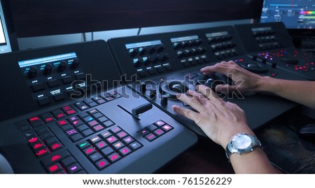 Telecine controller machine and man hand editing or adjusting color on digital video movie or film in the post production stage.