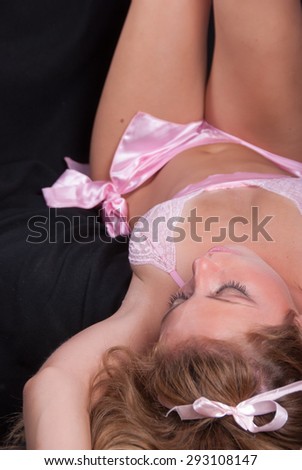 Sweet and sexy lady wearing a c-throu pink lingeries on couch from above