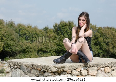 Fit young girl wearing sweater and shorts sitting with crossed legs
