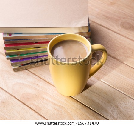coffee cup with the book on a wooden table.