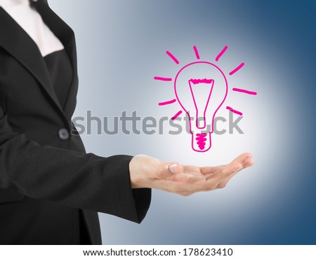 Light bulb in hand business woman on blue background.