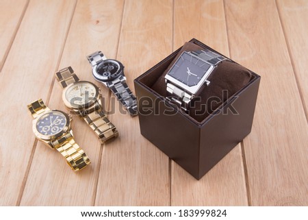 box with luxury watch on wooden background