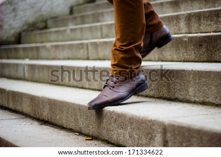 Walking downstairs: close-up view of man\'s leather shoes