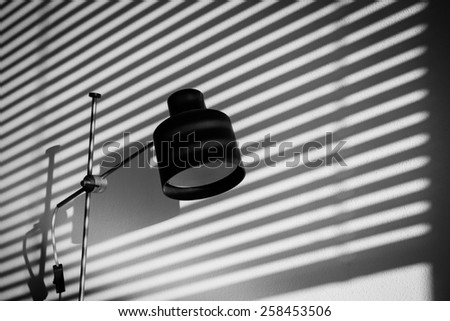 Contrasting black and white still life: Vintage lamp on a writer\'s or journalist\'s desk in the office