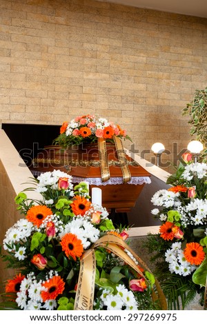 Funeral hall with wooden coffin and flower decoration, prepared for burial ceremony