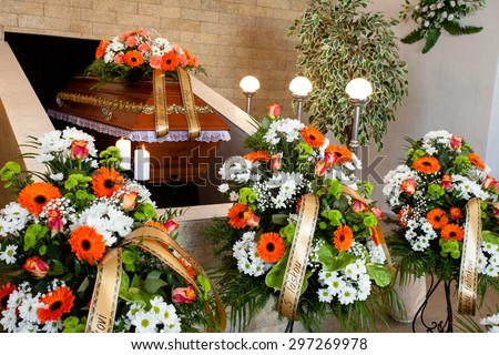 Funeral hall with wooden coffin and flower decoration, prepared for burial ceremony
