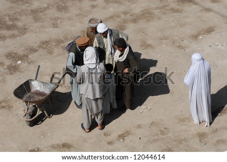 عكسهاي افغانستان Stock-photo-afghan-men-do-business-while-woman-in-burka-watches-12044614