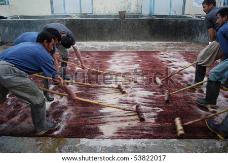 JALALABAD - JANUARY 27: Cadre of Afghan carpet washers wash carpet with brooms January 27, 2010 in Jalalabad, eastern Afghanistan.