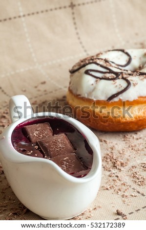 Donut with jam watered white chocolate. Dark chocolate, milk chocolate. Red jam. Very tasty looks for the menu. A delicious donut. Doughnut sprinkles milk chocolate.
