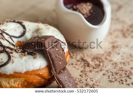 Donut with jam watered white chocolate. Dark chocolate, milk chocolate. Red jam. Very tasty looks for the menu. A delicious donut. Doughnut sprinkles milk chocolate.